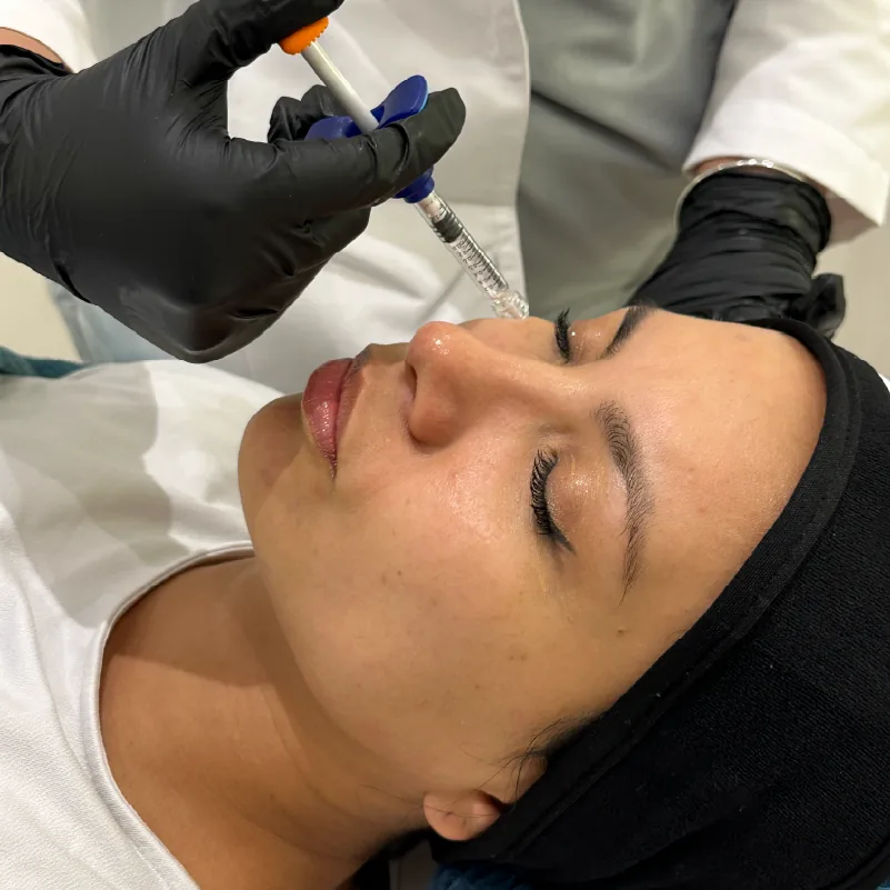 Mujer en consulta estética siendo evaluada por un profesional después de tratamiento facial con colágeno