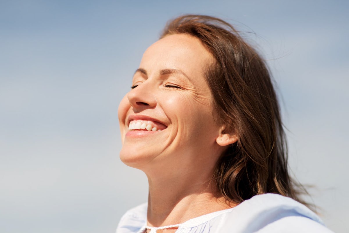 Prepara tu piel antes de las vacaciones: limpieza e hidratación profunda Mujer disfrutando con alegría sus vacaciones y su piel bien cuidada